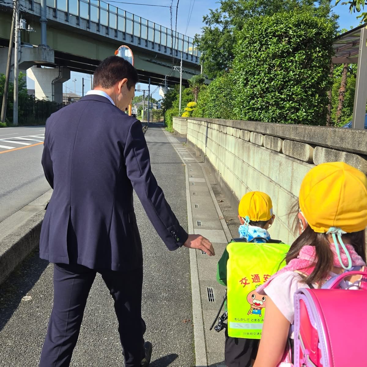 通学路で登校する児童を見守る